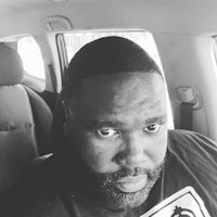 a black and white photo of a man in a car